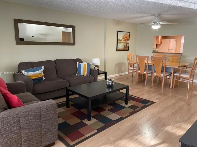 a living room with furniture a rug and a dining table