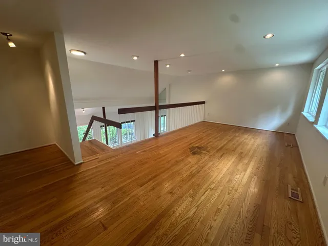 a view of empty room with wooden floor