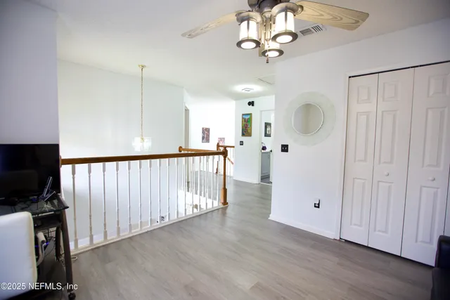 a view of a hallway with wooden floor and staircase