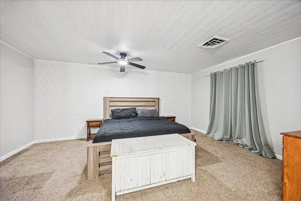 a bedroom with a bed and a ceiling fan