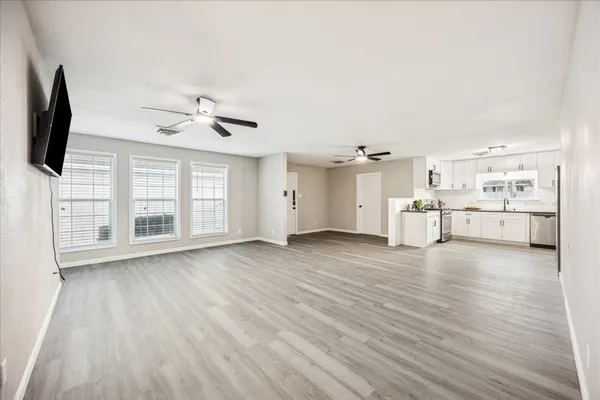 a view of a livingroom with wooden floor and a ceiling fan