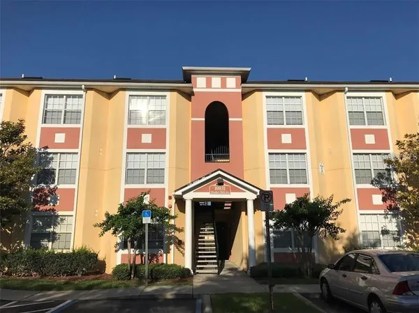 a front view of a building with a garden and plants