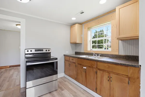 a kitchen with granite countertop a sink cabinets and window