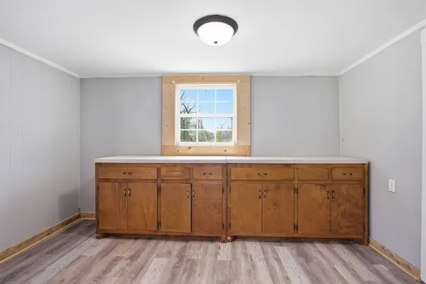 a view of a kitchen with wooden floor and window