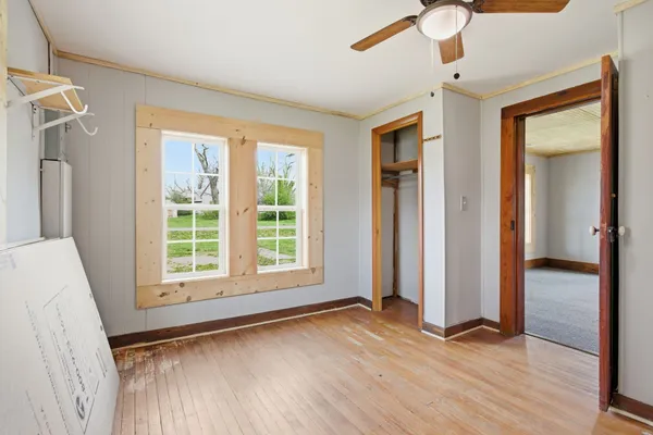 an empty room with wooden floor and a window