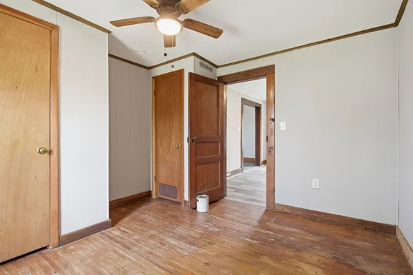 a view of empty room with wooden floor