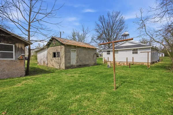 a view of a yard with a house and a large tree