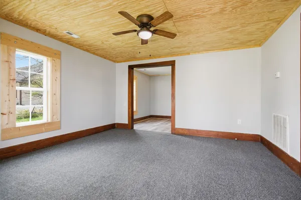 a view of a room with a ceiling fan and window