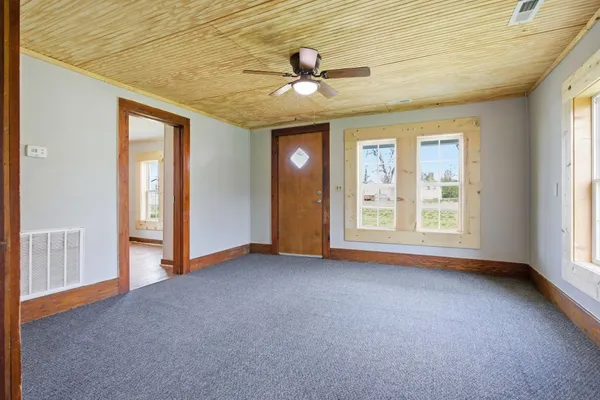 an empty room with windows and closet