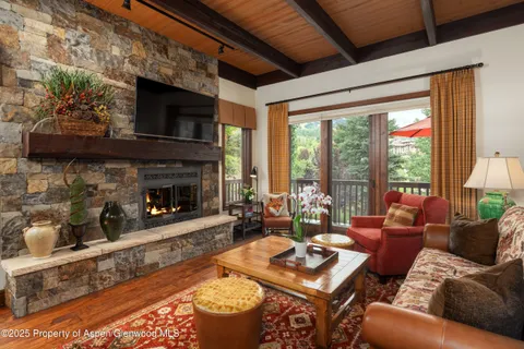 a living room with furniture large window and a fireplace
