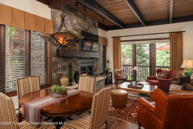 a living room with fireplace furniture and a large window