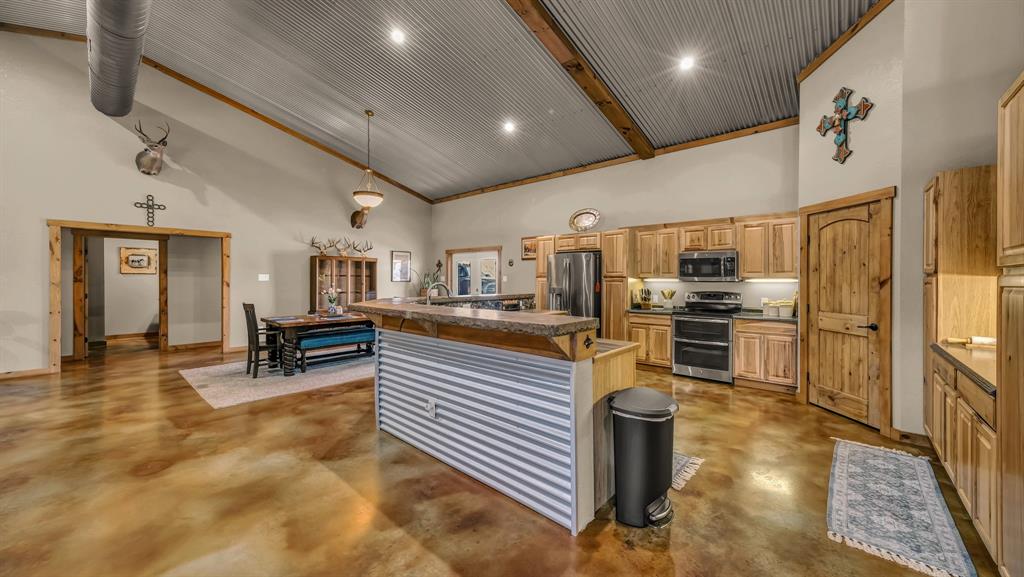 6500 Fm Road, Unit 1885 Weatherford, TX 76088 - Photo 9 of 40 a kitchen with stainless steel appliances a stove a refrigerator cabinets and living room view