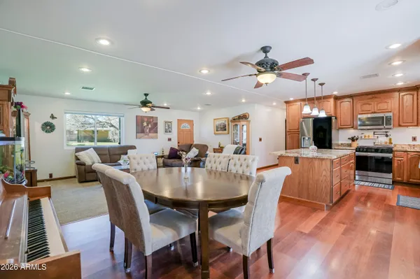 a view of a dining room with furniture a rug and wooden floor