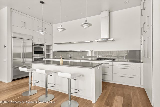 a kitchen with stainless steel appliances granite countertop a sink a stove and a refrigerator