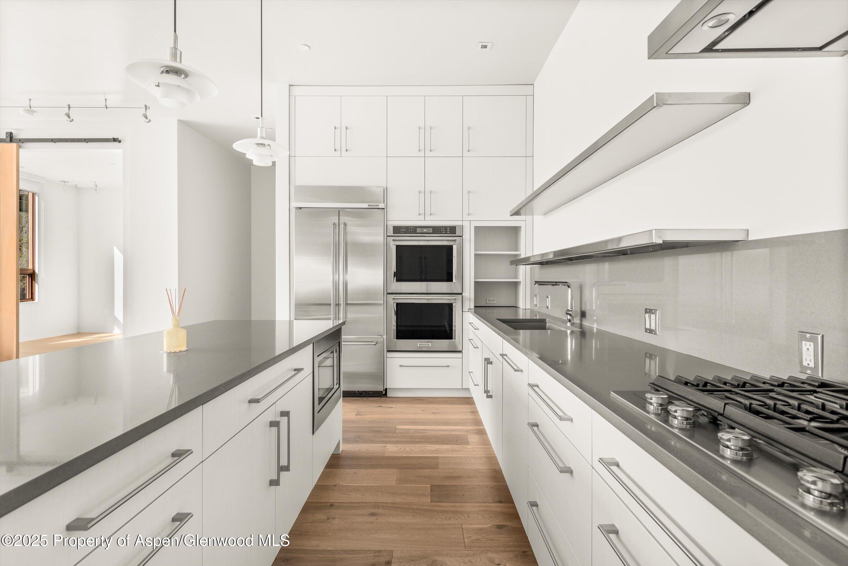 104 Evans Road, Unit 105 Basalt, CO 81621 - Photo 10 of 23 a large kitchen with kitchen island white cabinets and stainless steel appliances