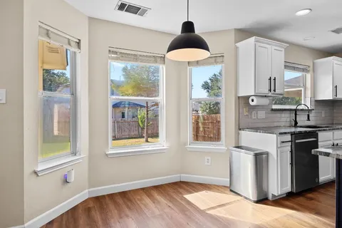 a kitchen with stainless steel appliances granite countertop a stove a sink and a large window