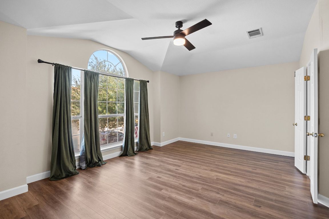 1405 Ty Cobb Place Round Rock, TX 78665 - Photo 21 of 33 an empty room with wooden floor fan and windows