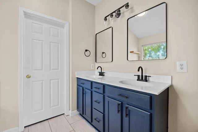 a bathroom with a double vanity sink and mirror