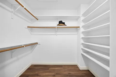 a view of walk in closet with empty racks