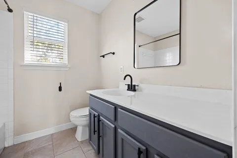 a bathroom with a sink a toilet and a mirror