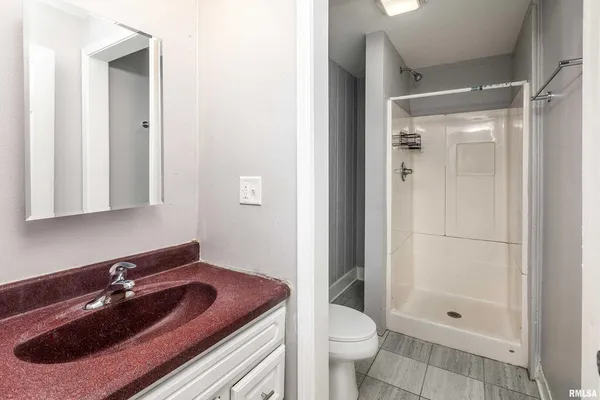 a view of a room with wooden floor and a bathroom