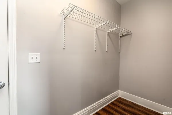a view of an empty room with wooden floor and closet