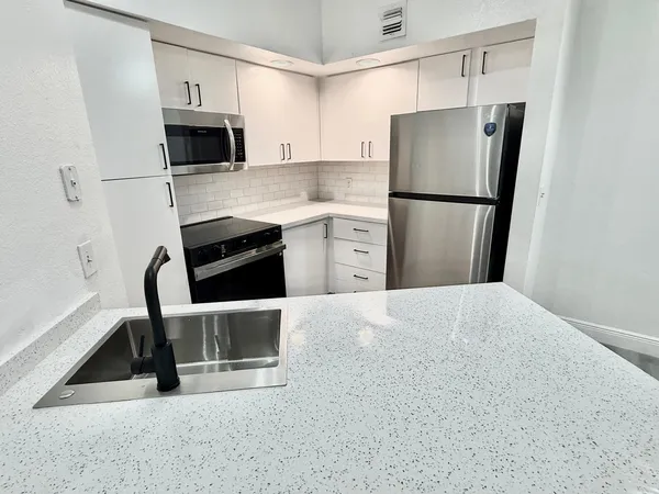 a kitchen with stainless steel appliances a refrigerator stove and microwave