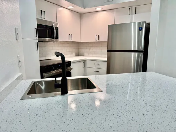 a kitchen with a refrigerator sink and cabinets