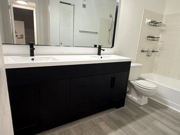 a bathroom with a sink vanity mirror and toilet