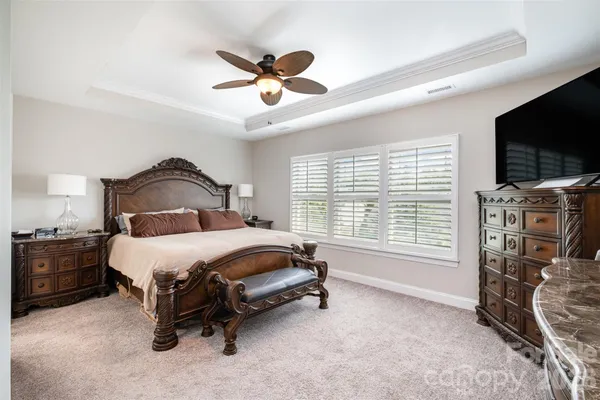 a bedroom with a bed flat screen tv and a large window