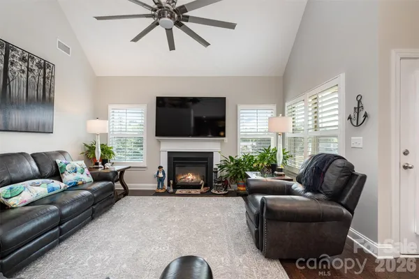 a living room with furniture a fireplace and a flat screen tv