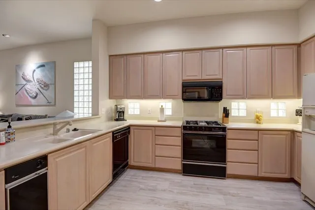a kitchen with stainless steel appliances granite countertop a stove sink and cabinets
