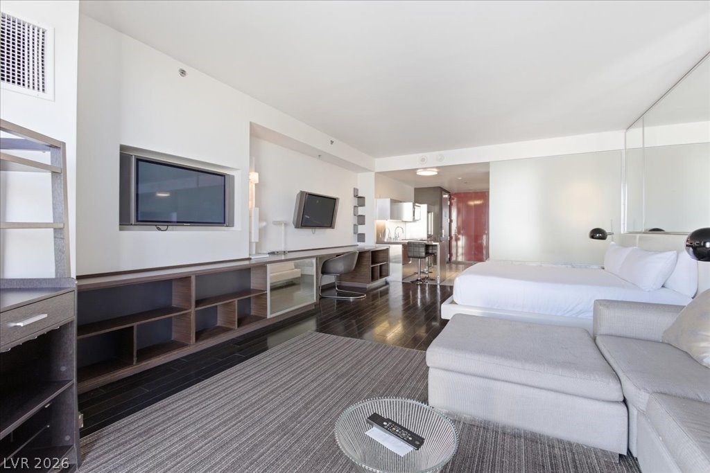 4381 West Flamingo Road, Unit 10306 Las Vegas, NV 89103 - Photo 10 of 26 This open concept living space features glossy hardwood flooring and integrated shelving.