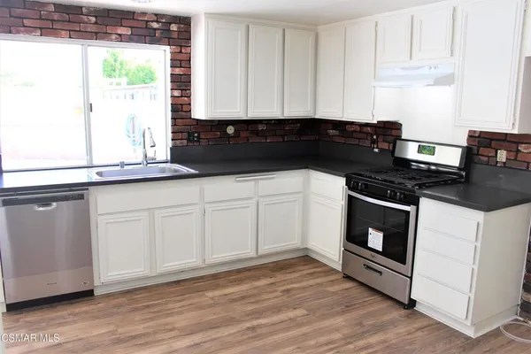 a kitchen with granite countertop white cabinets and black appliances