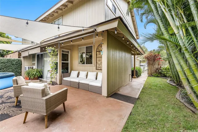a view of a house with backyard and sitting area