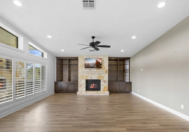 a view of an empty room with a fireplace and a window
