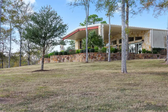 a view of a house with backyard and trees