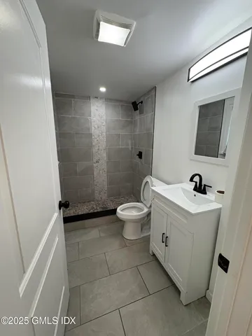 a bathroom with a bathtub sink mirror toilet and shower
