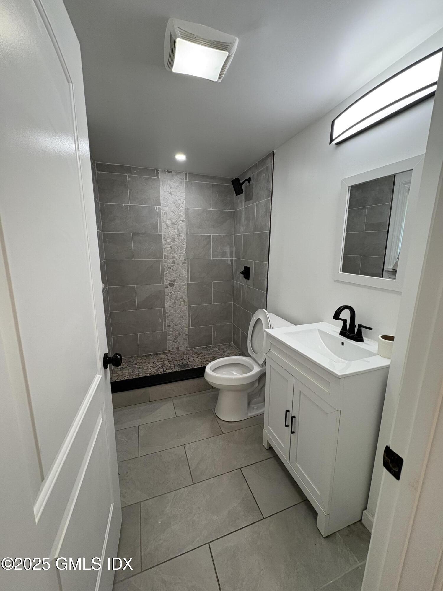 119 North Water Street, Unit A Greenwich, CT 06830 - Photo 6 of 7 a bathroom with a bathtub sink mirror toilet and shower