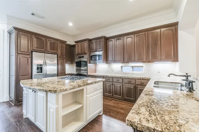 a kitchen with stainless steel appliances granite countertop a stove a refrigerator and a sink
