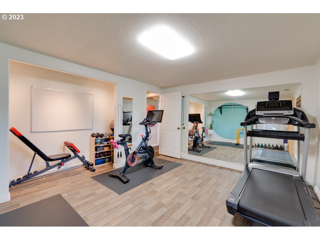 3250 P Street Washougal, WA 98671 - Photo 38 of 48 a living room with furniture a wooden floor and gym equipment