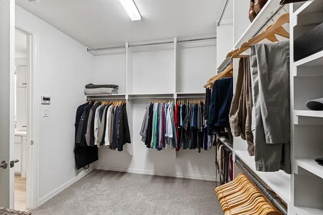 a view of walk in closet with clothes and shoes