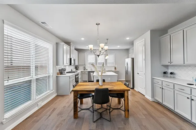 a kitchen with kitchen island a white cabinets and wooden floor