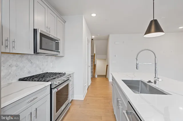 a kitchen with stainless steel appliances granite countertop a sink stove and cabinets