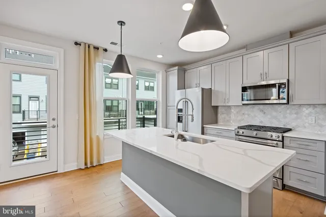 a kitchen with sink refrigerator and microwave