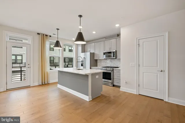 a open kitchen with stainless steel appliances granite countertop a stove and a refrigerator