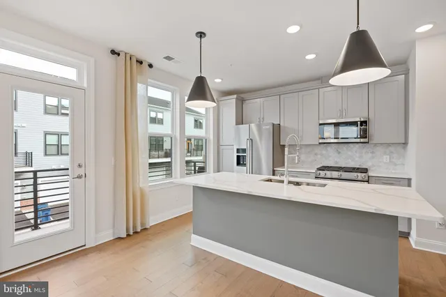 a kitchen with stainless steel appliances granite countertop a stove a sink and a refrigerator