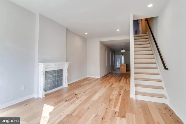 a view of a hallway with wooden floor and staircase
