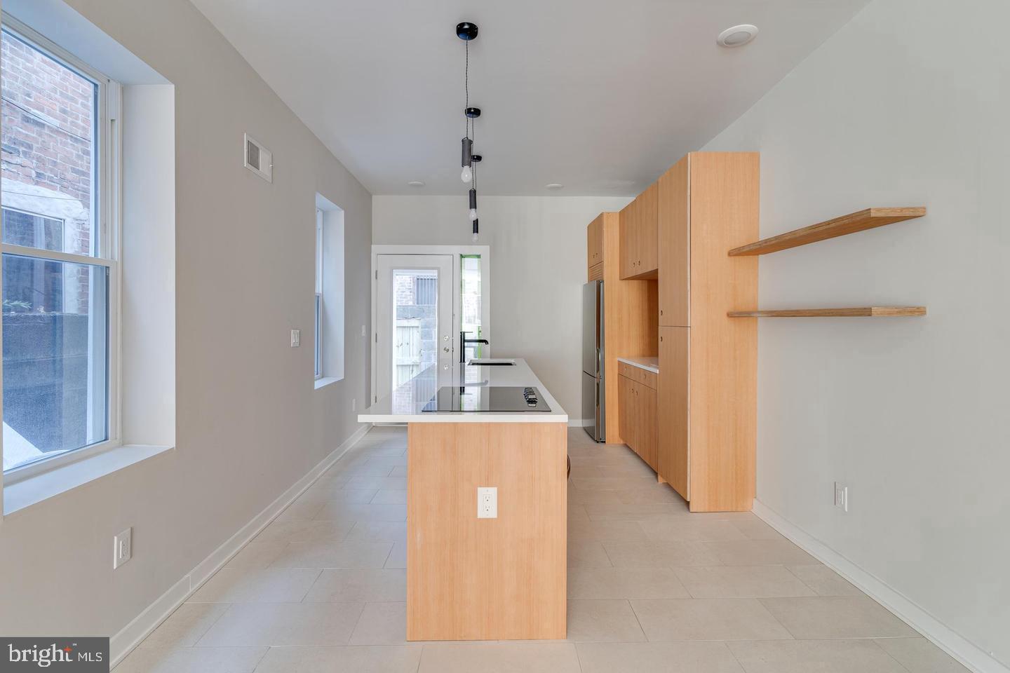 1503 North 29th Street Philadelphia, PA 19121 - Photo 5 of 27 a view of a kitchen with a refrigerator a kitchen island wooden floor and windows