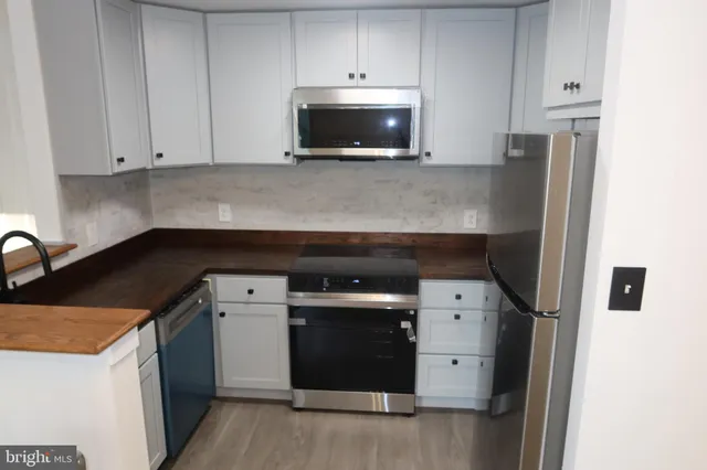 a kitchen with stainless steel appliances a stove microwave and refrigerator